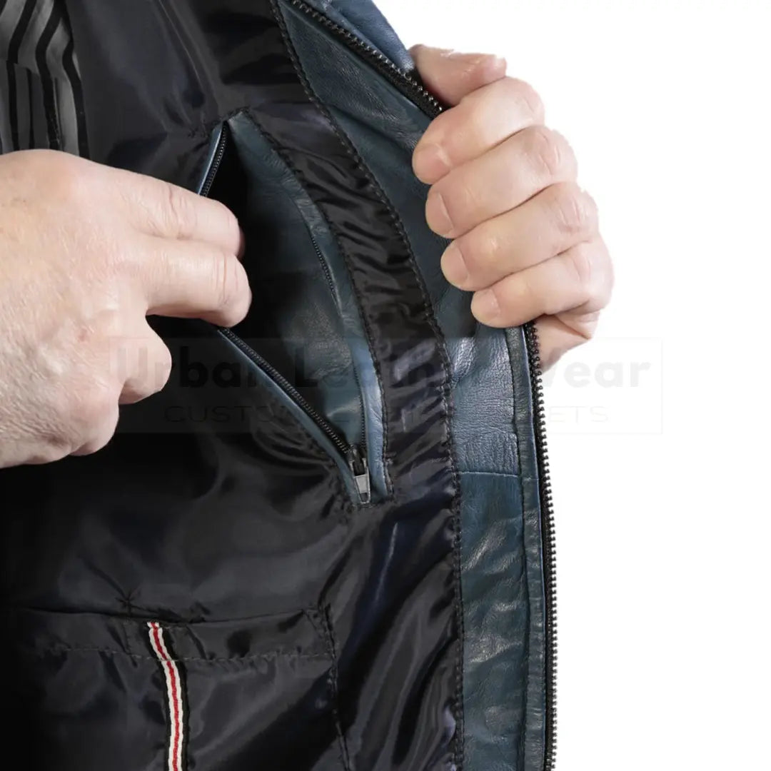 Person opening a Puffer men blue quilted leather padded jacket, showcasing its durable leather, front YKK zip closure, and quilted design for warmth and style.